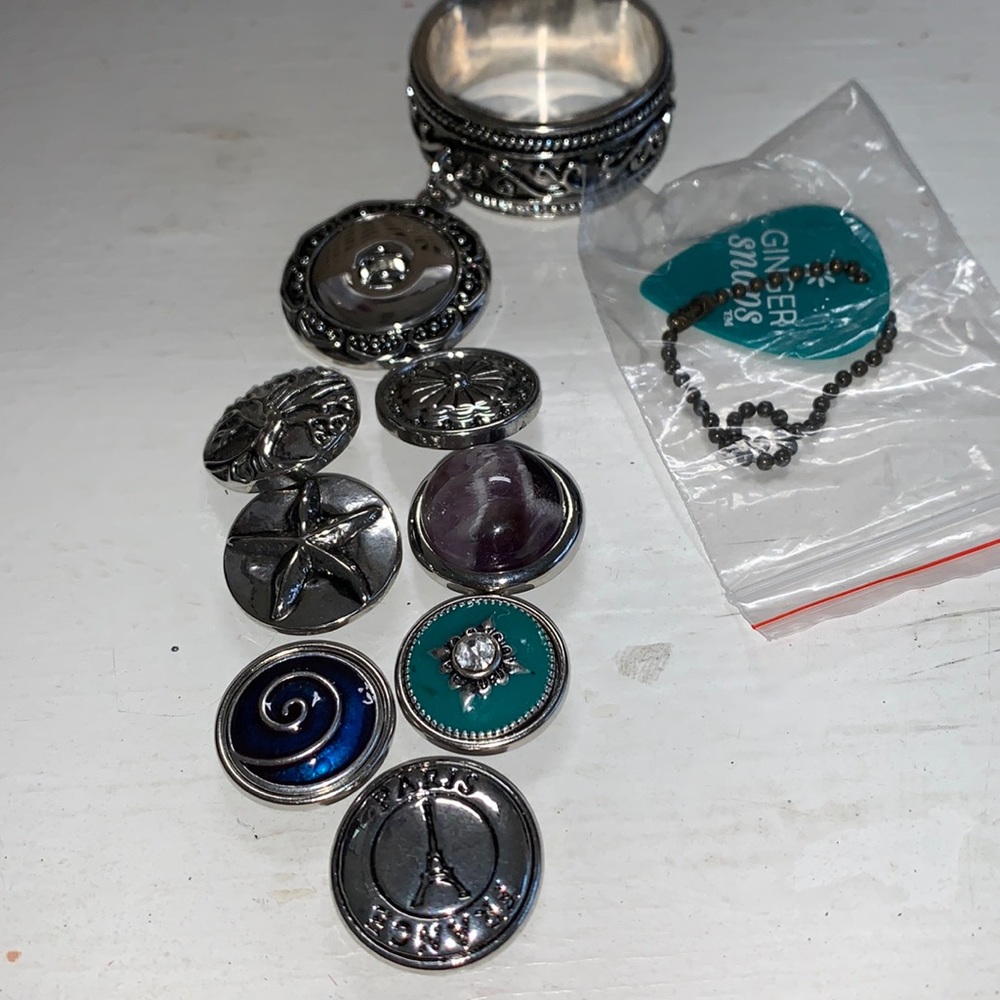 One silver tone scarf ring with 7 changeable snaps.  NWOT